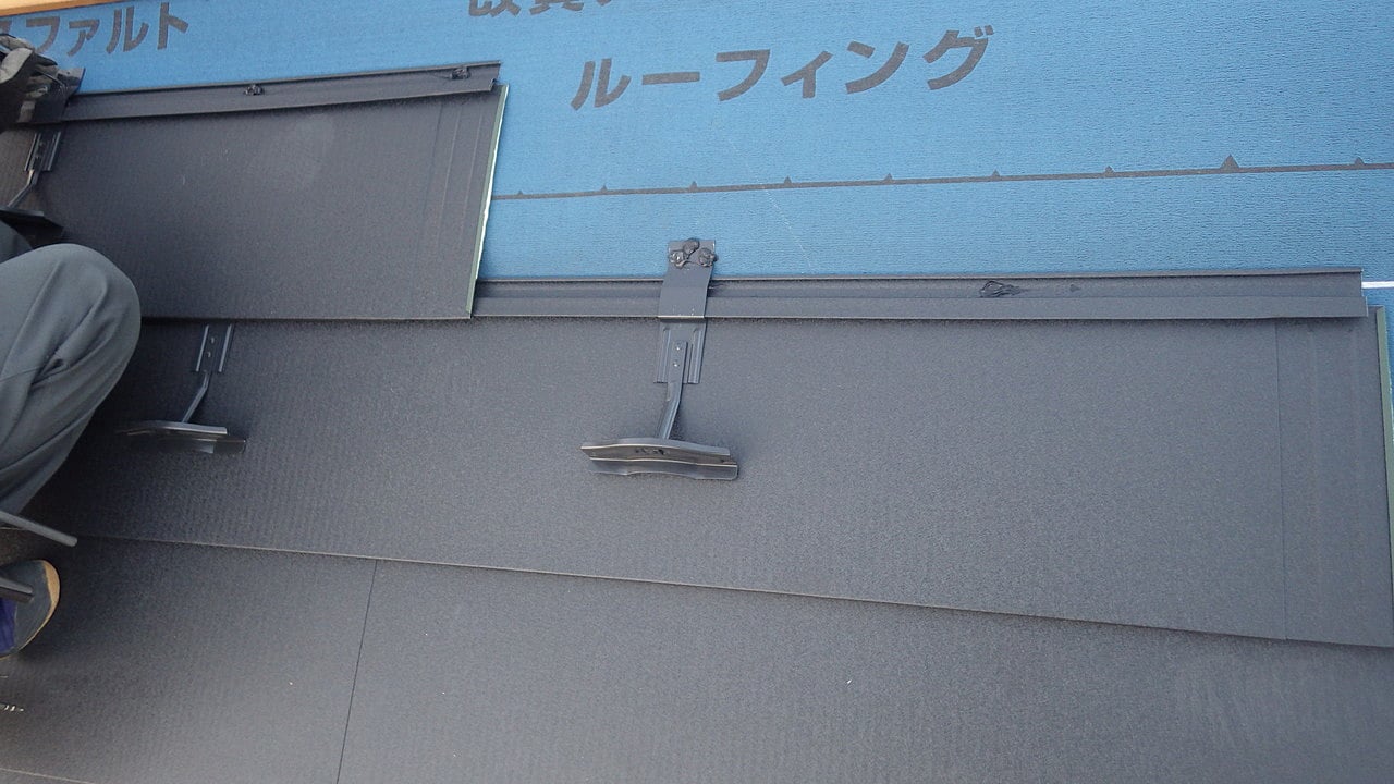 スレート屋根に新しい屋根材を取り付けている工事